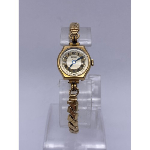 629 - LADIES 9CT GOLD CASED VISIBLE WRIST WATCH ON ELASTICATED GOLD CORE BRACELET STRAP