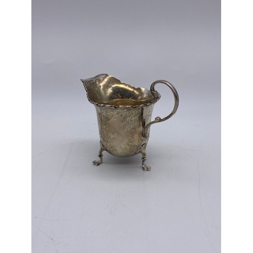 645 - BIRMINGHAM SILVER CREAMER JUG WITH LOOP HANDLE RAISED ON PAD FEET 1.5OZ APPROX