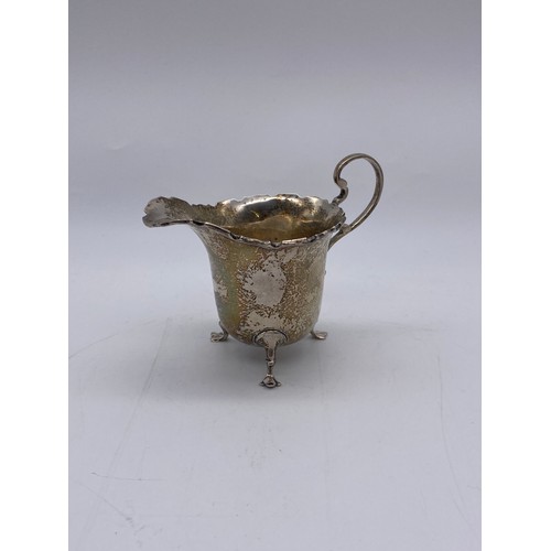 645 - BIRMINGHAM SILVER CREAMER JUG WITH LOOP HANDLE RAISED ON PAD FEET 1.5OZ APPROX