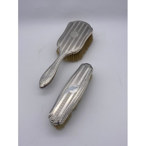 649 - TWO SILVER BACKED ENGINE TURNED DRESSING TABLE BRUSHES