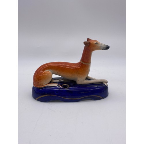 252 - STAFFORDSHIRE RECUMBENT WHIPPET INKWELL A/F AND PAIR OF SEATED SPANIELS