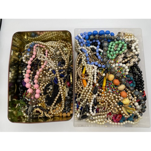 633 - TIN AND A TRAY OF COSTUME JEWELLERY INC. PEARL STRANDS AND NECKLACES