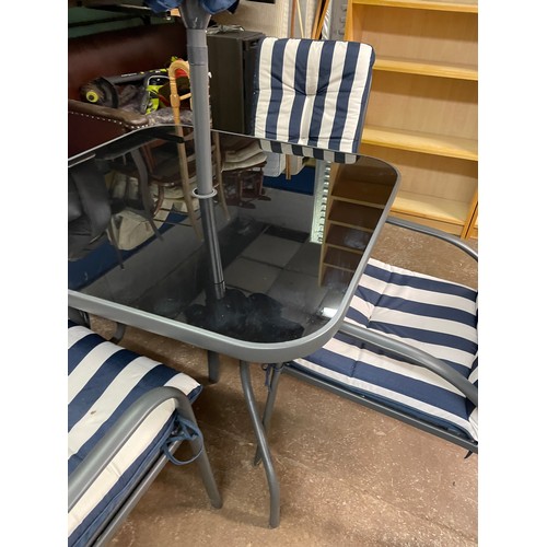 190 - GREY TUBULAR METAL PATIO TABLE AND FOUR STACKING CHAIRS WITH STRIPED CUSHIONS AND PARASOL