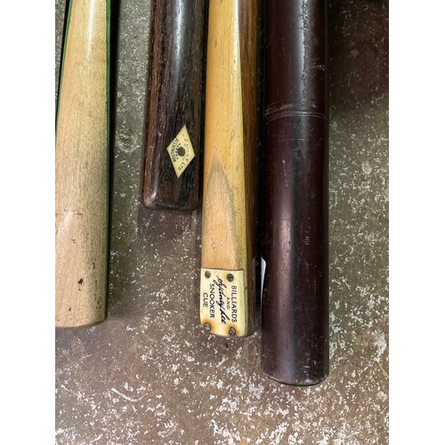 81 - TWO SNOOKER CUES IN TUBE HOLDERS, AND A COMBI CASE WITH CUE