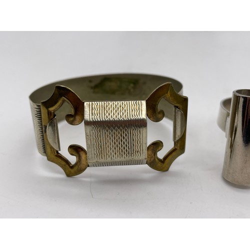 571 - METAL ENGINE TURNED BUCKLE BANGLE, AND A MODERNIST TYPE BANGLE