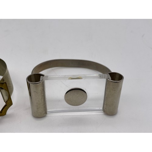 571 - METAL ENGINE TURNED BUCKLE BANGLE, AND A MODERNIST TYPE BANGLE