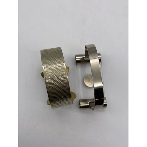 571 - METAL ENGINE TURNED BUCKLE BANGLE, AND A MODERNIST TYPE BANGLE