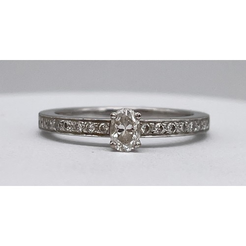 567 - STAMPED 750 18CT WHITE GOLD CLAW SET DIAMOND RING WITH DIAMOND CHIP SHOULDERS SIZE M