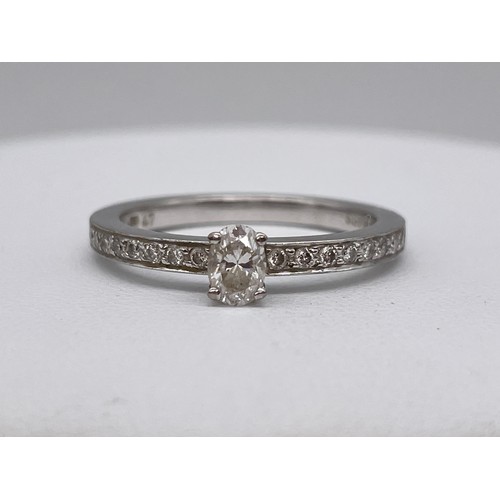 567 - STAMPED 750 18CT WHITE GOLD CLAW SET DIAMOND RING WITH DIAMOND CHIP SHOULDERS SIZE M