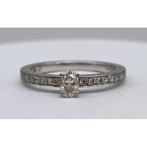 567 - STAMPED 750 18CT WHITE GOLD CLAW SET DIAMOND RING WITH DIAMOND CHIP SHOULDERS SIZE M