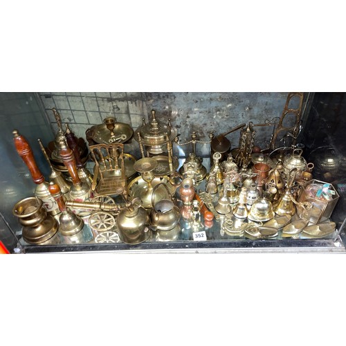 352 - SHELF OF DECORATIVE ORNAMENTAL BRASSWARES INC BELLS, CHAMBER STICKS, SLIPPERS, ETC