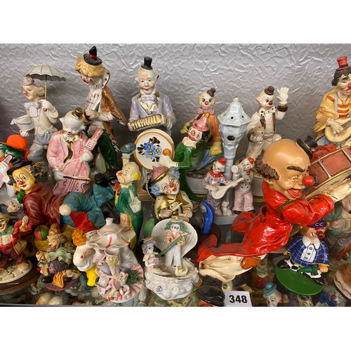 348 - SHELF OF VARIOUS POTTERY AND RESIN CLOWN FIGURE GROUPS