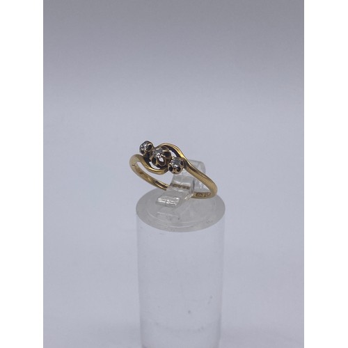 570 - 18CT GOLD THREE STONE CROSS OVER RING