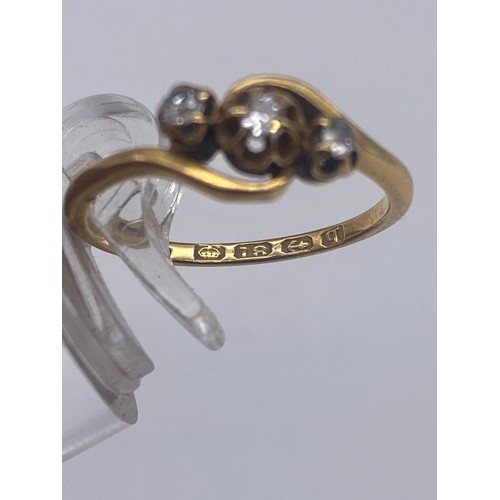 570 - 18CT GOLD THREE STONE CROSS OVER RING