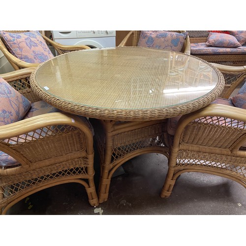 50 - BAMBOO AND CANE WORK CIRCULAR GLASS TOP TABLE AND FOUR ARMCHAIRS WITH LOOSE CUSHIONS