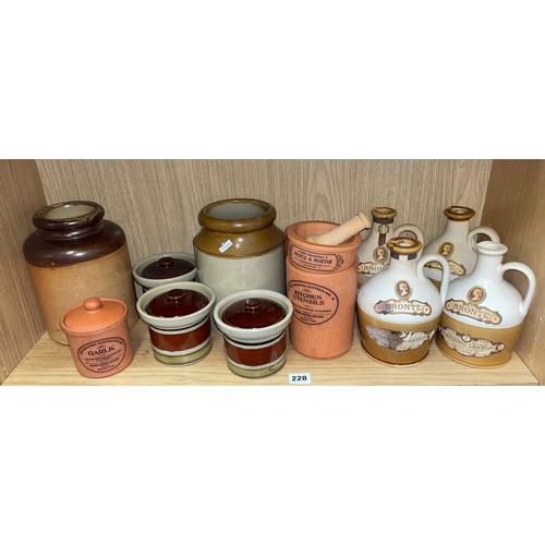 228 - SHELF OF STONEWARE FLAGONS, TERRACOTTA KITCHEN STORAGE POTS, A PESTLE AND MORTAR, AND TWO STONEWARE ... 