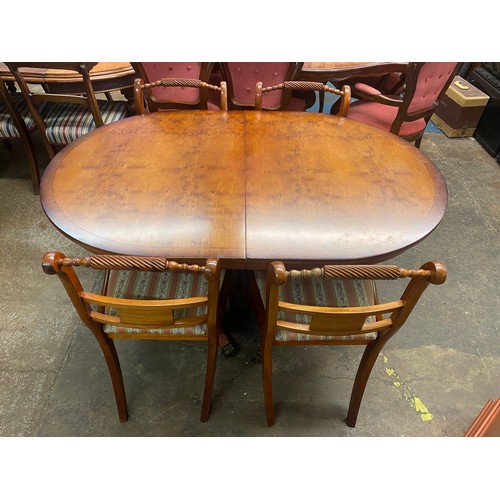 8 - REPRODUCTION YEW REGENCY STYLE DINING TABLE WITH FOUR SABRE LEG BRASS INLAID ROPE BACK CHAIRS