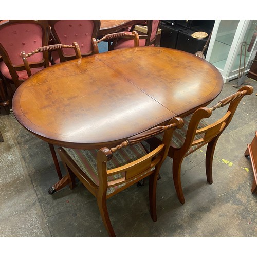 8 - REPRODUCTION YEW REGENCY STYLE DINING TABLE WITH FOUR SABRE LEG BRASS INLAID ROPE BACK CHAIRS