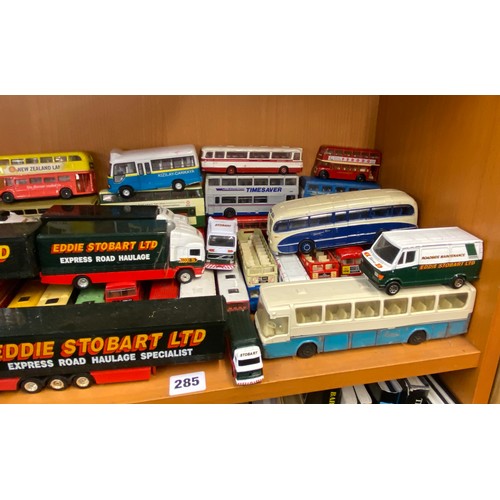 285 - TWO SHELVES OF DIE CAST MODELS OF DOUBLE DECKER BUSES, COACHES AND SOME EDDIE STOBART HAULAGE TRUCKS... 