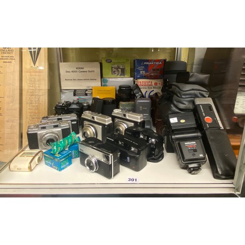 301 - TWO SHELVES OF 35MM CAMERAS INCLUDING ZENIT, VARIOUS LENSES, MIRANDA FLASH GUN, DISC CAMERA OUTFITS ... 