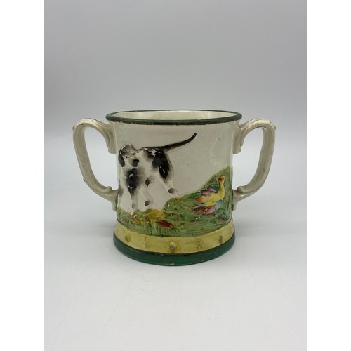 519 - 19TH CENTURY TWIN HANDLED STAFFORDSHIRE FROG LOVING CUP WITH HUNTING DOG DECORATION