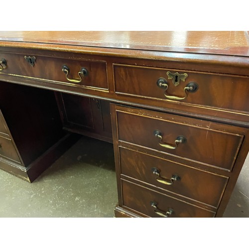 124 - GOOD QUALITY REPRODUCTION KNEEHOLE MAHOGANY NINE DRAWER DESK WITH BROWN GILT TOOLED SKIVER