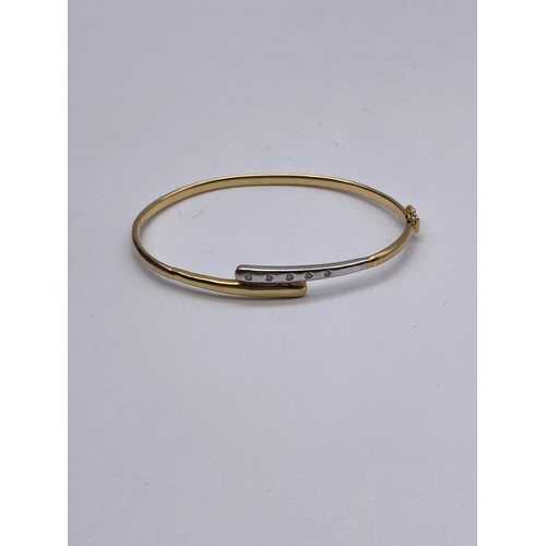 712 - 18K YELLOW AND WHITE GOLD CROSS OVER BANGLE 6G APPROX