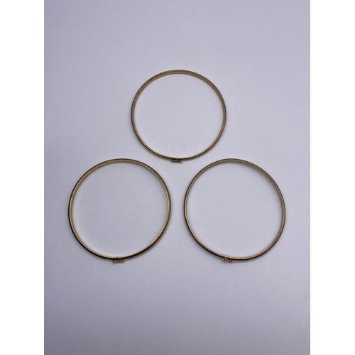 704 - THREE 9CT GOLD BANGLES 12G OVERALL APPROX