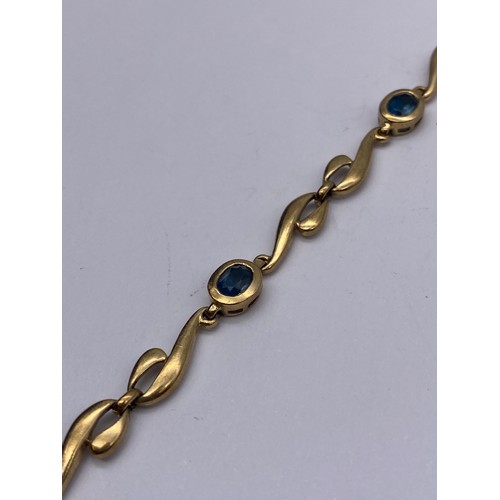 711 - 9CT GOLD WAVE LINK AND AQUA STONE BRACELET 8G APPROX