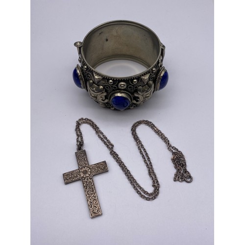 693 - ETHNIC WHITE METAL AND BLUE CABOCHON CUFF BANGLE AND A SILVER CROSS ON TRACE CHAIN