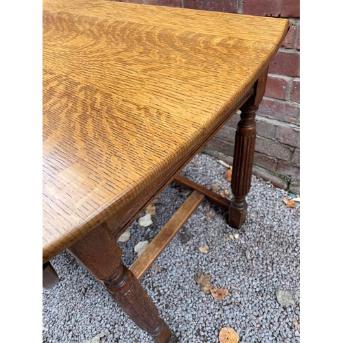 115 - OAK OVAL DROP FLAP DINING TABLE ON FLUTED LEGS