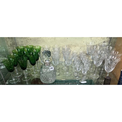 292 - SHELF OF CUT GLASSWARE INC WINE FLUTES, BOTTLE GREEN GLASSES, AND AN EPNS COLLAR DECANTER