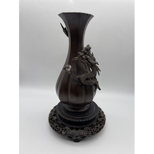 441 - JAPANESE BRONZE LOBED VASE DECORATED WITH DRAGON AND ORB ON HARDWOOD STAND