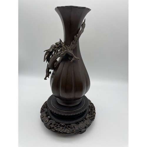 441 - JAPANESE BRONZE LOBED VASE DECORATED WITH DRAGON AND ORB ON HARDWOOD STAND