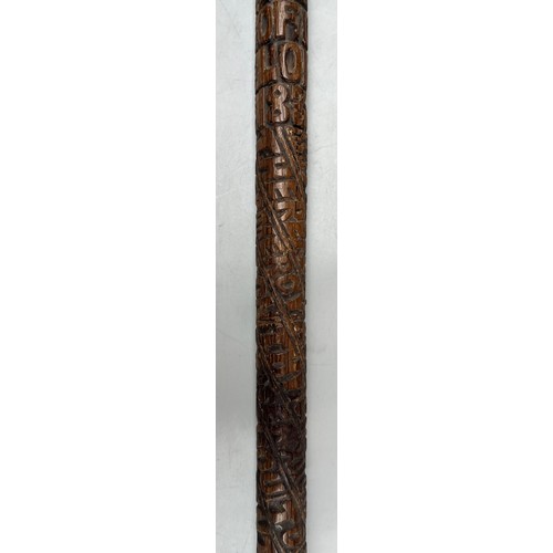 216 - INTERESTING CARVED WOODEN WALKING STICK DATED WITH NAME AND RELIGOUS TEXT (SANS HANDLE)