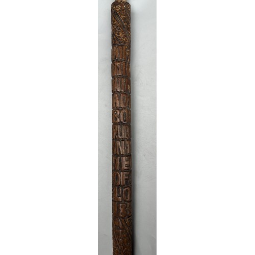 216 - INTERESTING CARVED WOODEN WALKING STICK DATED WITH NAME AND RELIGOUS TEXT (SANS HANDLE)