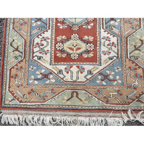 234 - 20TH CENTURY CAUCASIAN CARPET WITH LOZENGE MEDALLIONS ON A CENTRAL RUSSET PANEL WITHIN GEOMETRIC BOR... 