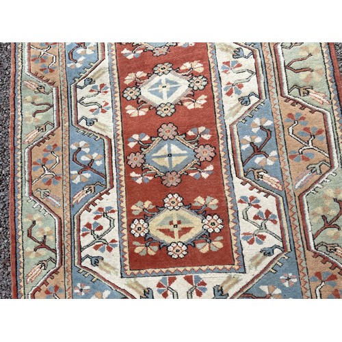 234 - 20TH CENTURY CAUCASIAN CARPET WITH LOZENGE MEDALLIONS ON A CENTRAL RUSSET PANEL WITHIN GEOMETRIC BOR... 