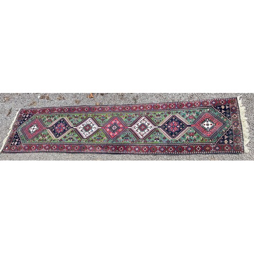 232 - 20TH CENTURY CAUCASIAN CARPET RUNNER WITH LOZENGE MEDALLIONS ON A GREEN GROUND 68CM X 288CM APPROX