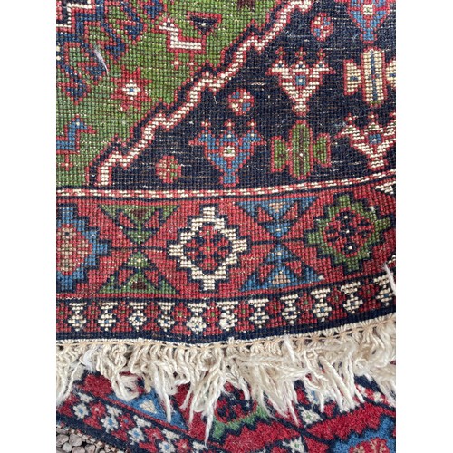 232 - 20TH CENTURY CAUCASIAN CARPET RUNNER WITH LOZENGE MEDALLIONS ON A GREEN GROUND 68CM X 288CM APPROX