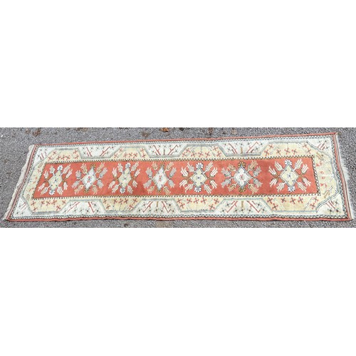 231 - 20TH CENTURY CAUCASIAN CARPET RUNNER WITH GEOMETRIC PATTERN ON TERRACOTTA CENTRAL GROUND 82CM X 282C... 