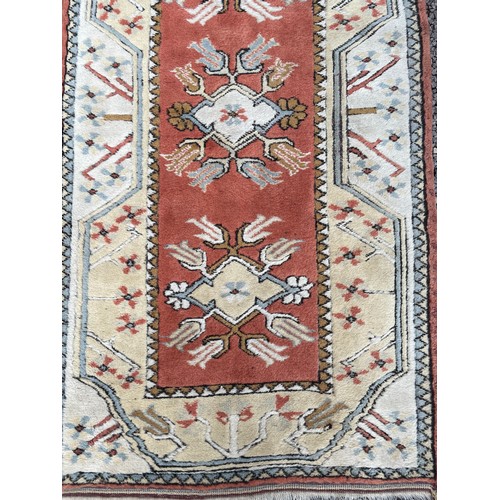 231 - 20TH CENTURY CAUCASIAN CARPET RUNNER WITH GEOMETRIC PATTERN ON TERRACOTTA CENTRAL GROUND 82CM X 282C... 