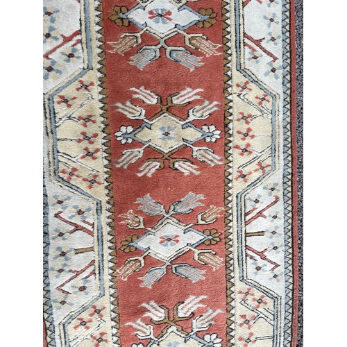 231 - 20TH CENTURY CAUCASIAN CARPET RUNNER WITH GEOMETRIC PATTERN ON TERRACOTTA CENTRAL GROUND 82CM X 282C... 