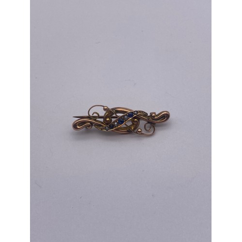 762 - 9CT ROSE GOLD SWIRL BAR BROOCH WITH BLUE STONES AND SEED PEARLS 1.6G APPROX