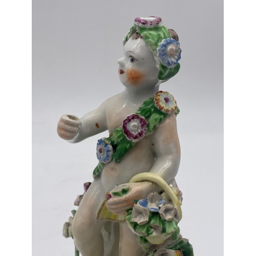 696 - 18TH CENTURY BOW PORCELAIN FIGURE OF A PUTTO WITH FLOWER BASKET A/F (RED ANCHOR AND DAGGER MARK TO B... 