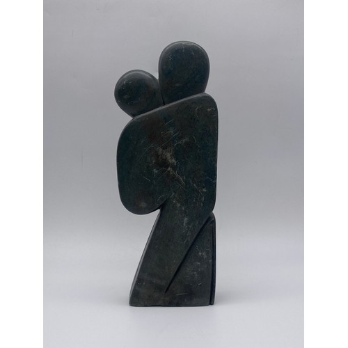 680 - CARVED SOAPSTONE SCULPTURE OF A COUPLE SIGNED PHINEAS KAMANGIRA