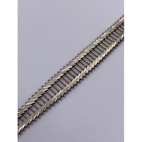 393 - STAMPED 750 WHITE GOLD HERRINGBONE BRACELET WITH SAFETY CLASP 23G APPROX