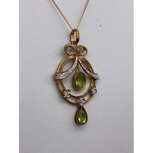 425 - EDWARDIAN CIRCULAR DISC PERIDOT AND DIAMOND BOW PENDANT ON FINE TRACE CHAIN 4.1G APPROX