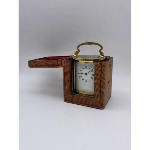 374 - LEATHER CASED TRAVELLING GILT BRASS OVAL CARRIAGE CLOCK