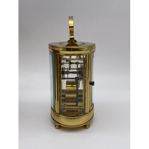 374 - LEATHER CASED TRAVELLING GILT BRASS OVAL CARRIAGE CLOCK